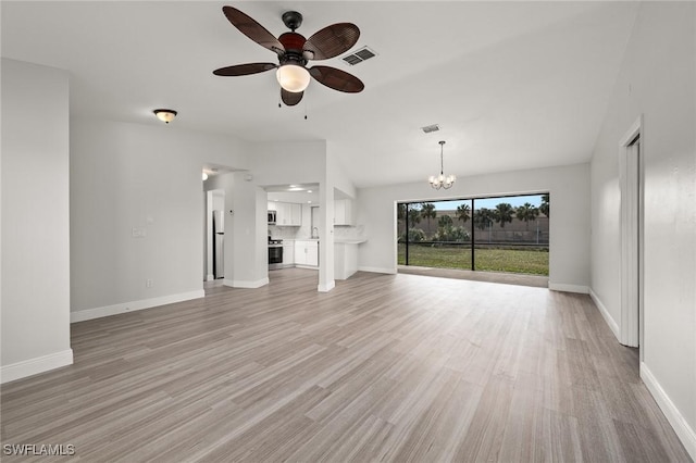 unfurnished living room featuring vaulted ceiling, ceiling fan with notable chandelier, and light hardwood / wood-style floors