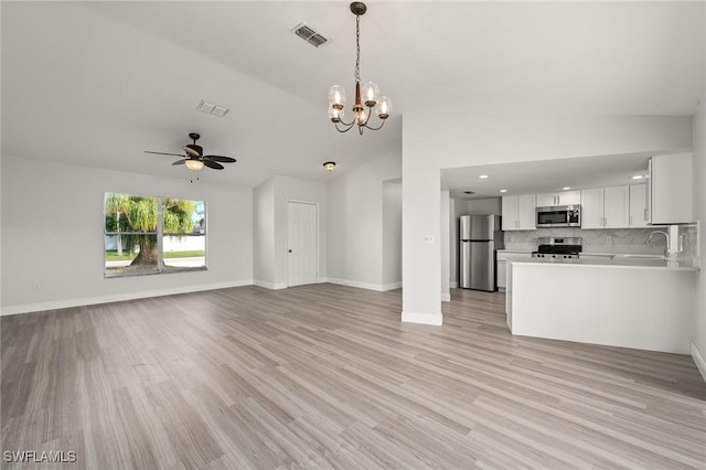 unfurnished living room with ceiling fan with notable chandelier, sink, light hardwood / wood-style floors, and vaulted ceiling