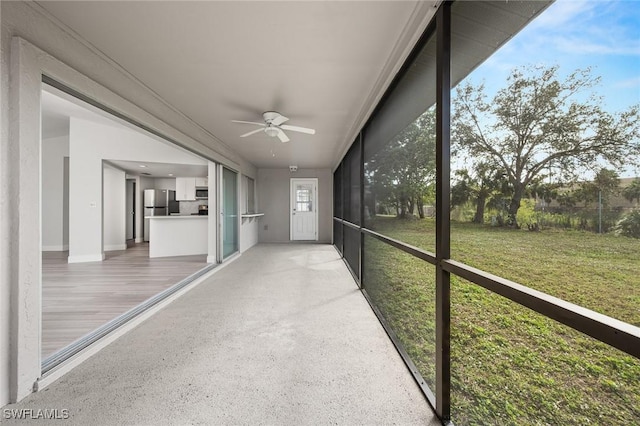 unfurnished sunroom featuring ceiling fan