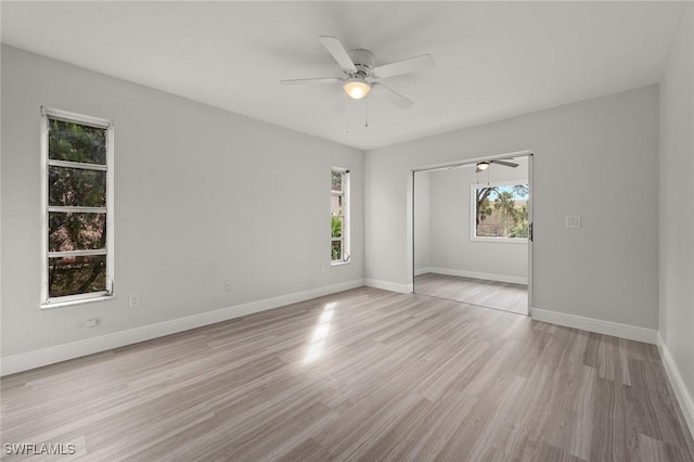 empty room with ceiling fan and light hardwood / wood-style floors