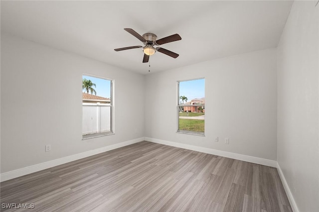 spare room featuring plenty of natural light, hardwood / wood-style floors, and ceiling fan