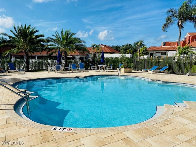 community pool with fence and a patio