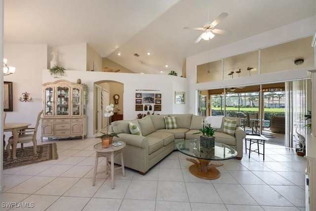 living area featuring arched walkways, high vaulted ceiling, light tile patterned floors, and ceiling fan