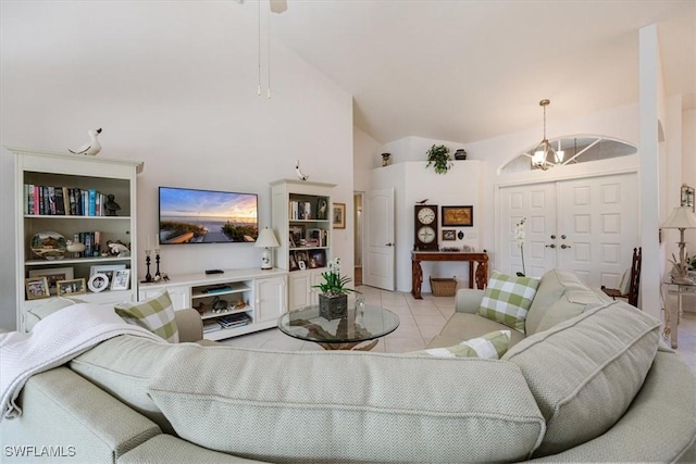 living area featuring high vaulted ceiling, light tile patterned flooring, and an inviting chandelier