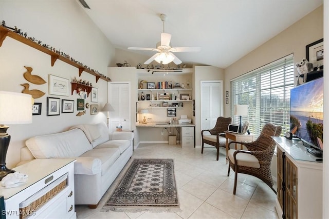 living area featuring lofted ceiling, light tile patterned flooring, visible vents, a ceiling fan, and built in desk