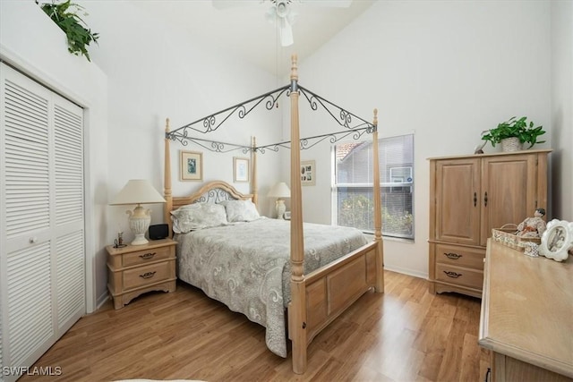 bedroom featuring light wood-style floors, a ceiling fan, high vaulted ceiling, and a closet