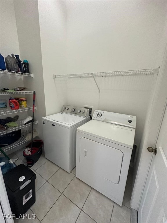 washroom featuring separate washer and dryer and light tile patterned flooring