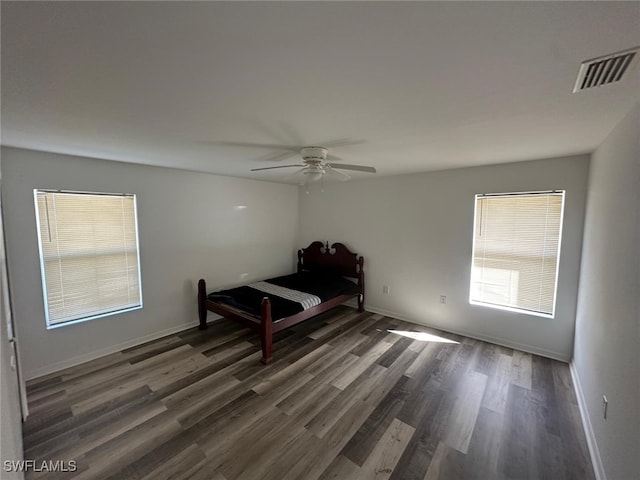 unfurnished bedroom with dark hardwood / wood-style floors and ceiling fan