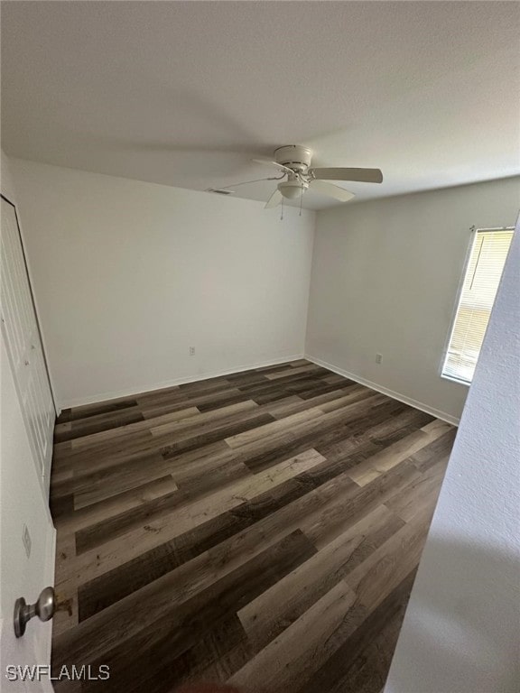 spare room with ceiling fan and dark hardwood / wood-style floors