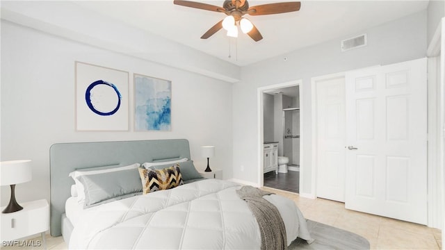 tiled bedroom with ceiling fan and ensuite bath