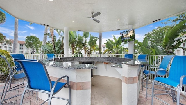 view of patio / terrace with exterior bar and ceiling fan