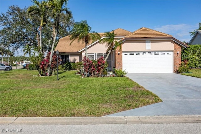 view of front facade featuring an attached garage, driveway, a tiled roof, stucco siding, and a front lawn