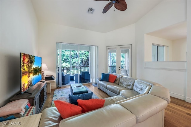 living room featuring french doors, ceiling fan, vaulted ceiling, and light hardwood / wood-style flooring