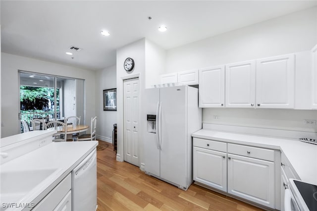 kitchen with sink, white appliances, light hardwood / wood-style flooring, and white cabinets