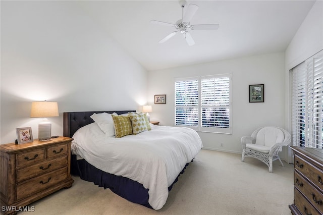 bedroom with baseboards, ceiling fan, light colored carpet, and vaulted ceiling