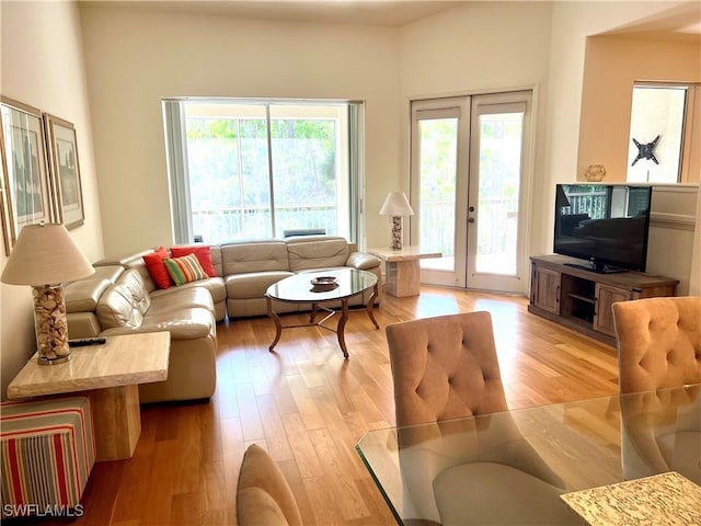living area with light wood-style flooring and french doors