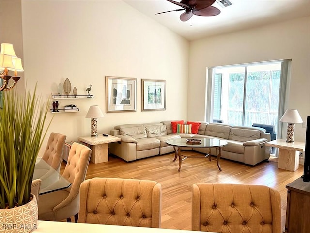 living room with visible vents, light wood-type flooring, and ceiling fan