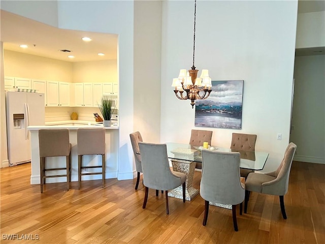 dining space featuring light wood-style floors, visible vents, recessed lighting, a notable chandelier, and baseboards