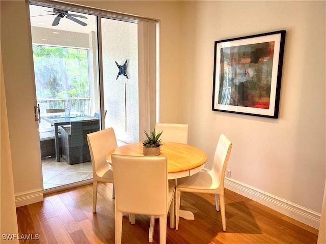 dining space featuring baseboards, a ceiling fan, and wood finished floors