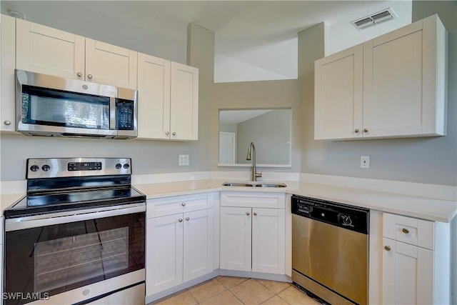 kitchen with white cabinetry, appliances with stainless steel finishes, light tile patterned flooring, and sink