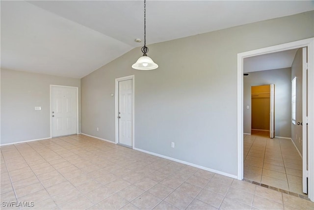 tiled empty room with lofted ceiling