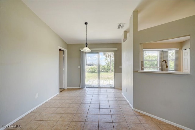 tiled empty room featuring plenty of natural light