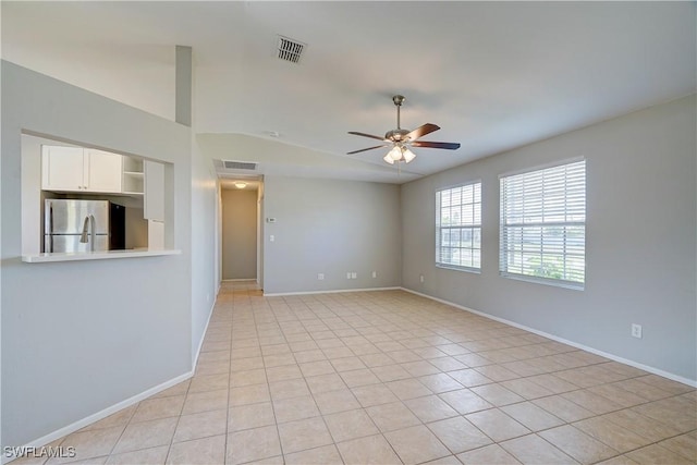 tiled empty room with ceiling fan and lofted ceiling