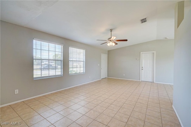 spare room with lofted ceiling, light tile patterned floors, and ceiling fan