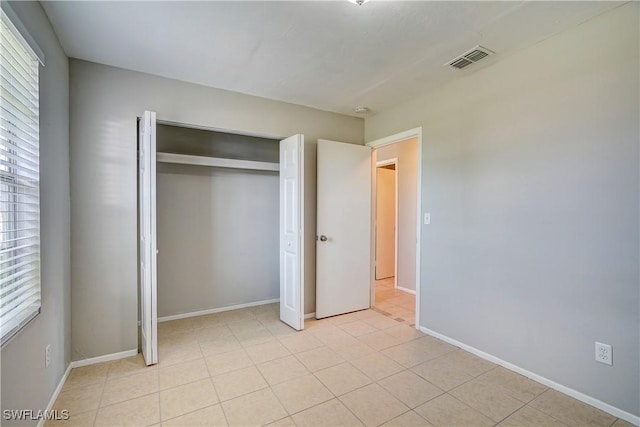 unfurnished bedroom featuring light tile patterned flooring and a closet