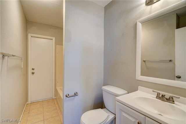 bathroom featuring tile patterned floors, toilet, vanity, and a tub