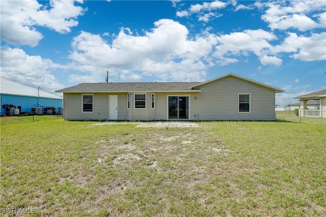 back of property with a yard and central air condition unit