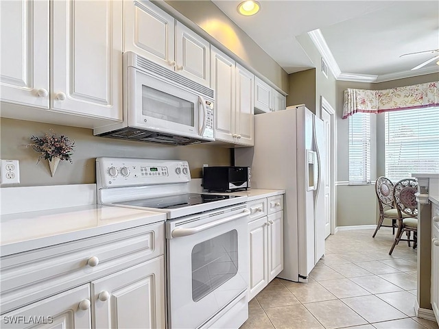 kitchen with light tile patterned flooring, white appliances, ornamental molding, and white cabinets