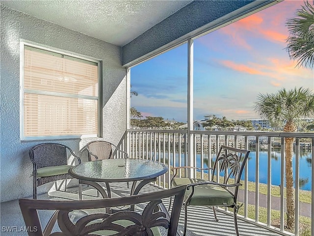 sunroom / solarium featuring a water view