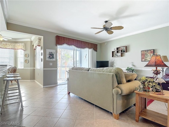 living room with plenty of natural light, ornamental molding, ceiling fan, and light tile patterned flooring