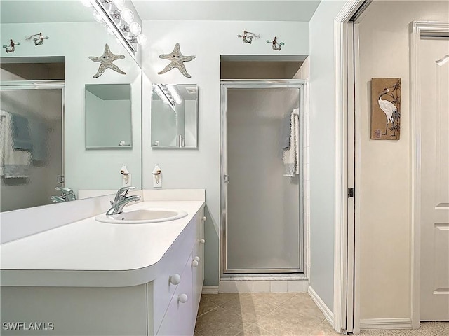 bathroom featuring vanity, tile patterned flooring, and a shower with door