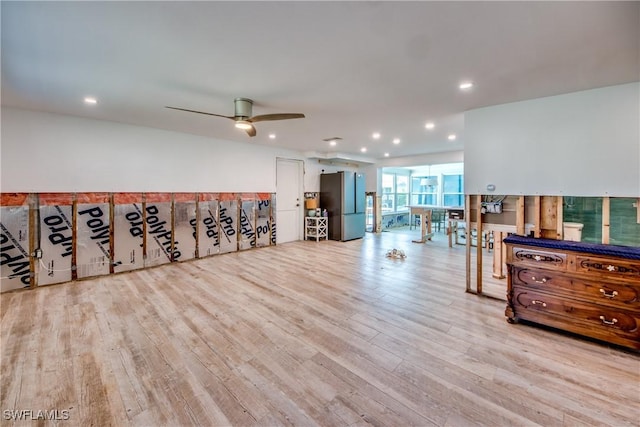 workout area with ceiling fan and light hardwood / wood-style floors