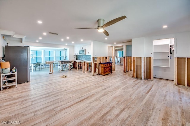 living room with ceiling fan and light wood-type flooring