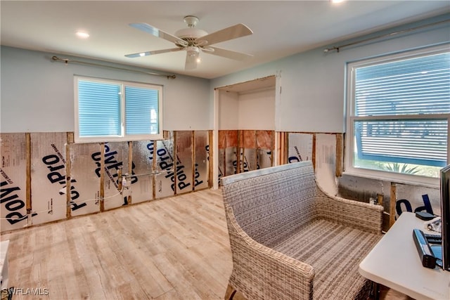 interior space with wainscoting, wood finished floors, and a ceiling fan