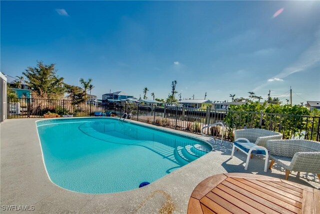 view of swimming pool featuring a water view and a patio area