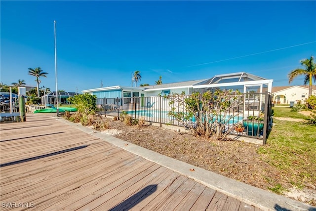 exterior space featuring a fenced in pool and glass enclosure