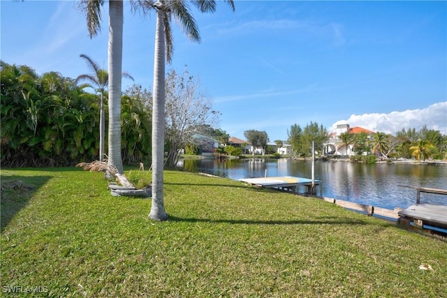 dock area with a lawn and a water view