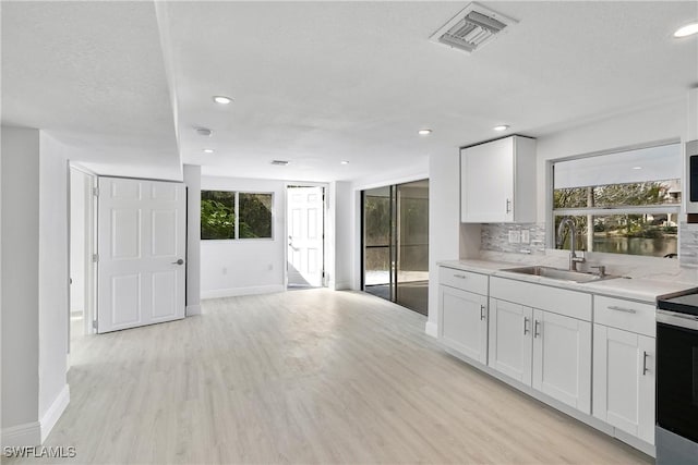 kitchen featuring white cabinetry, sink, decorative backsplash, and plenty of natural light