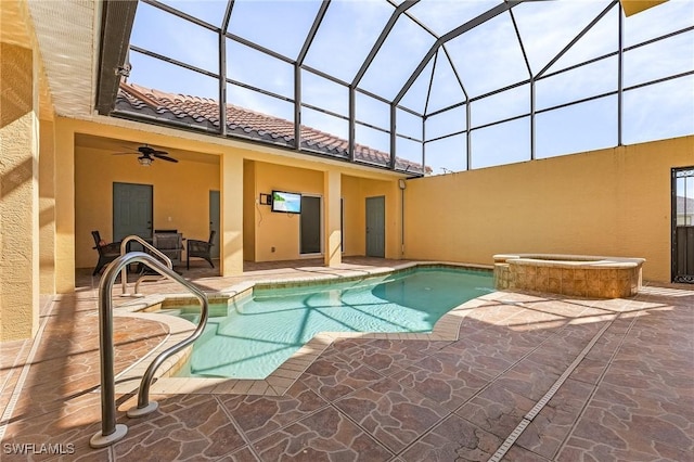 view of pool featuring an in ground hot tub, ceiling fan, glass enclosure, and a patio area