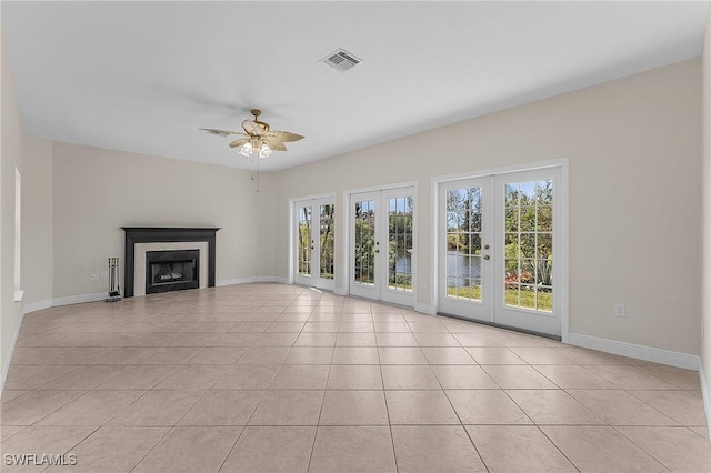 unfurnished living room with french doors, ceiling fan, and light tile patterned floors