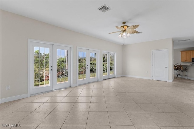 unfurnished living room featuring french doors, ceiling fan, and light tile patterned floors