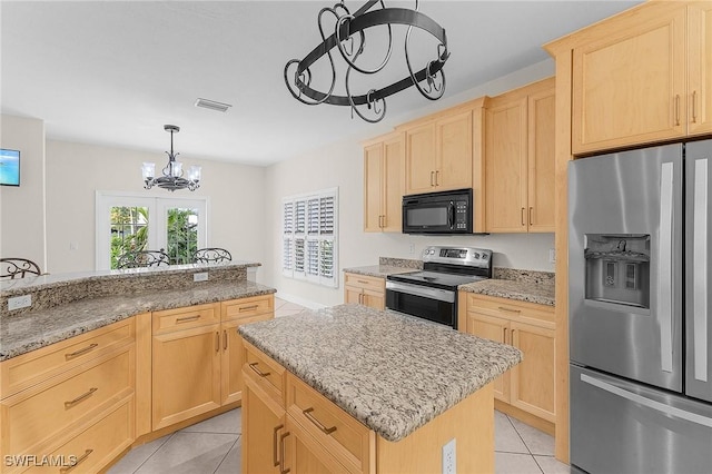 kitchen featuring light brown cabinetry, stainless steel appliances, a chandelier, and a kitchen island