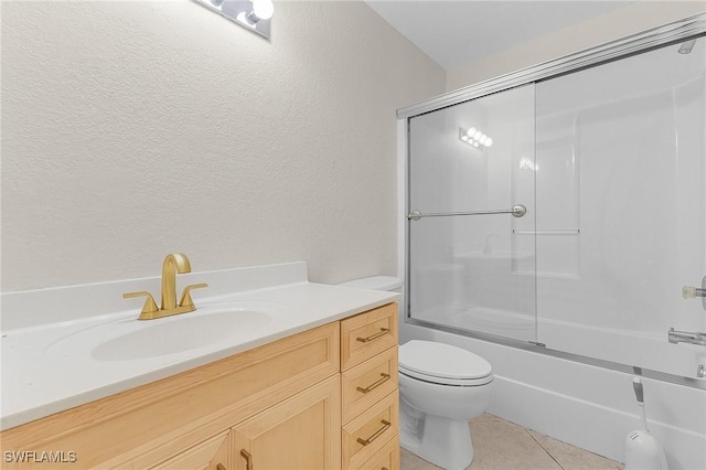 full bathroom featuring vanity, bath / shower combo with glass door, tile patterned floors, and toilet