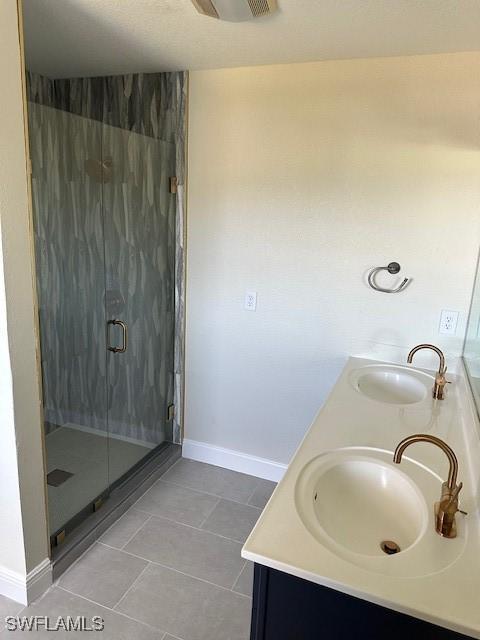 bathroom featuring vanity, tile patterned floors, and a shower with shower door