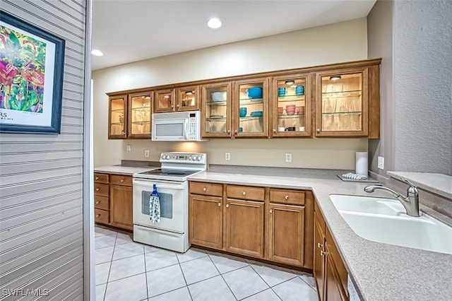 kitchen with white appliances, sink, and light tile patterned floors