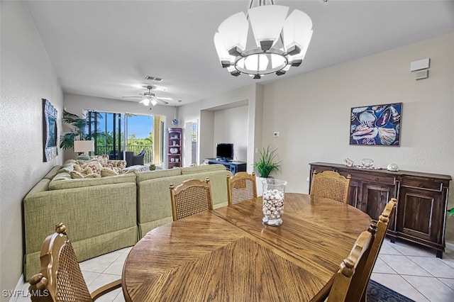 tiled dining room with ceiling fan with notable chandelier